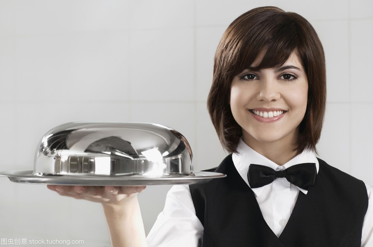 服務(wù)員拿著一個(gè)圓頂?shù)谋P(pán)子